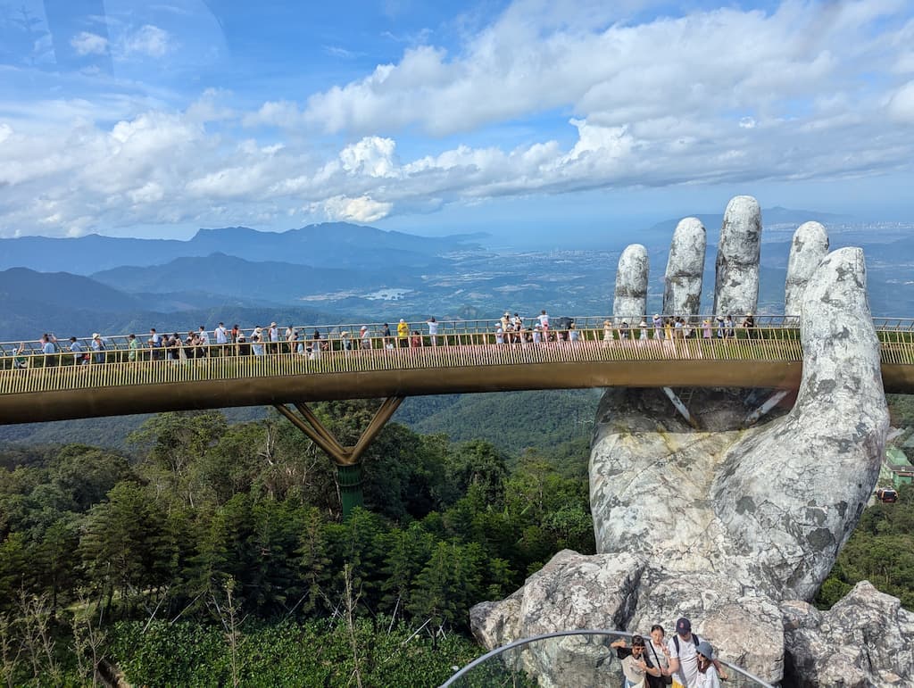 Vue frontale du Golden Bridge avec main en pierre et panorama montagneux