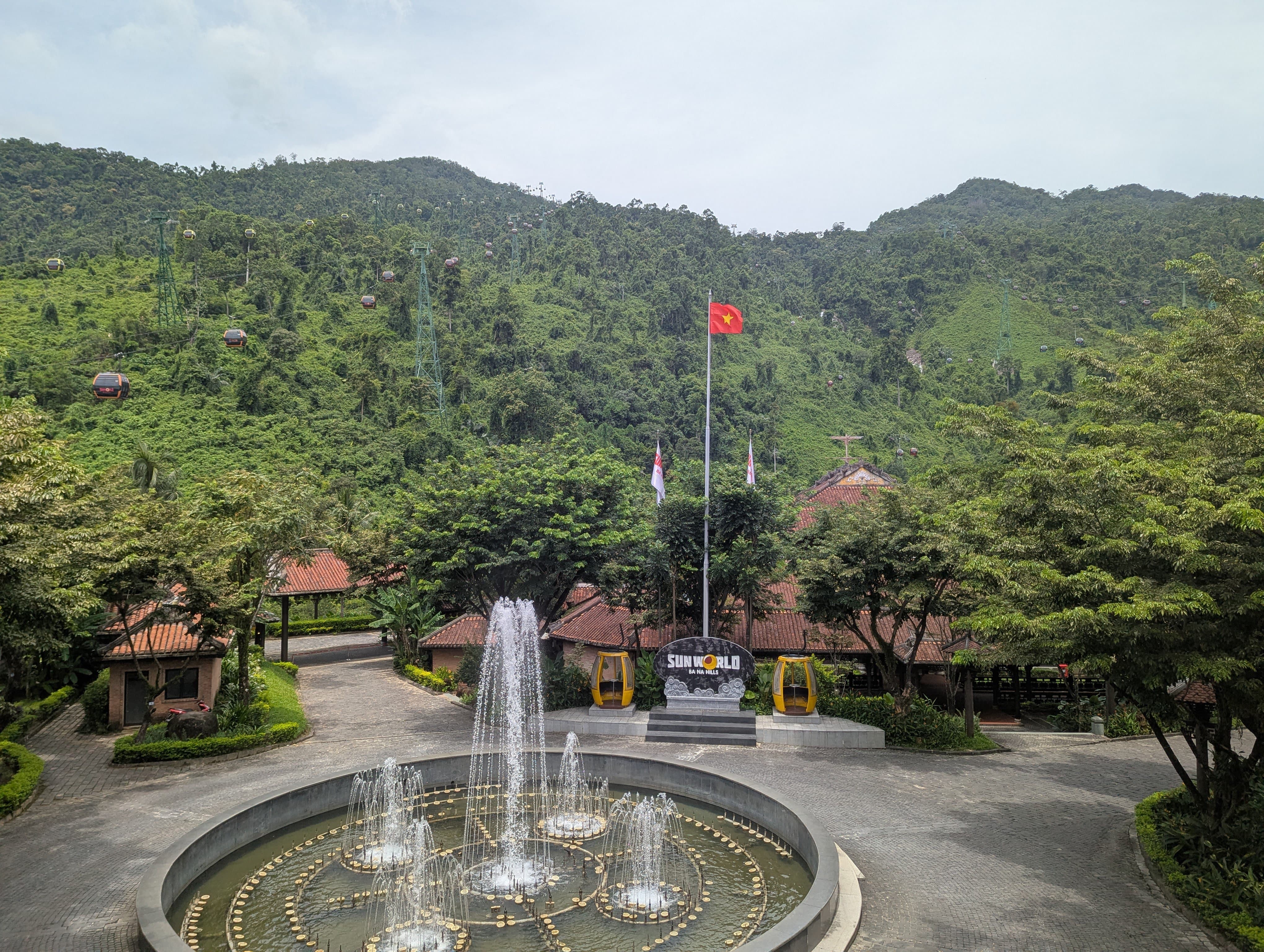 Fontaine et drapeau vietnamien devant la station inférieure du téléphérique de Ba Na Hills.