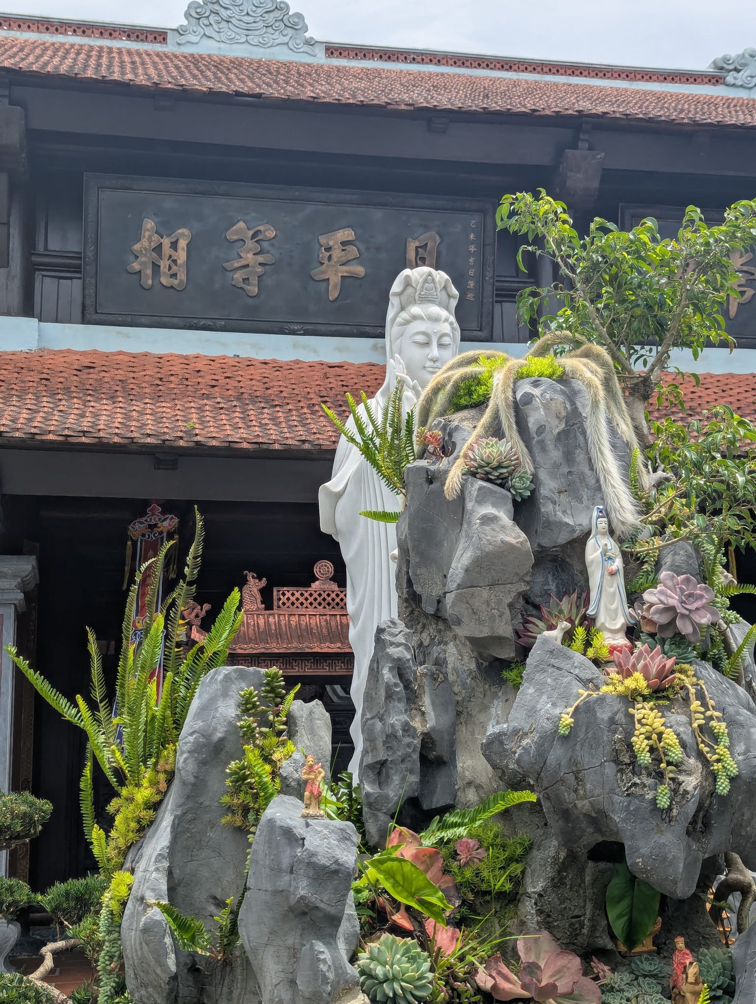 Statue blanche de la déesse de la compassion (Guanyin) devant un temple à Ba Na Hills.
