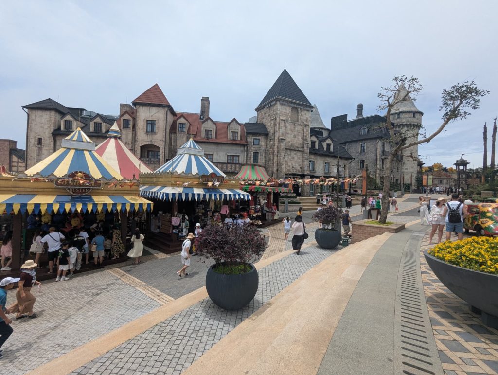Stands colorés de jeux et architecture européenne dans le village français de Ba Na Hills.